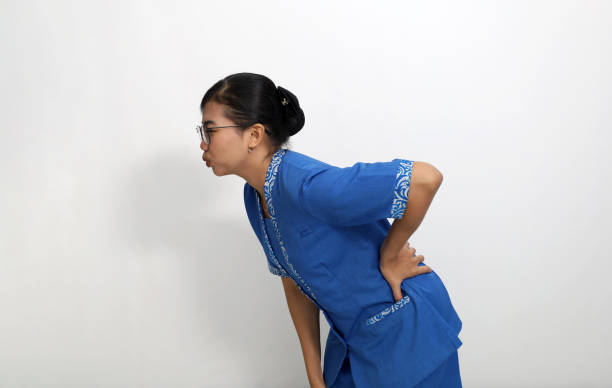 young asian employee suffering from back pain. isolated on white with copyspace - inflammation back physical therapy isolated on white imagens e fotografias de stock