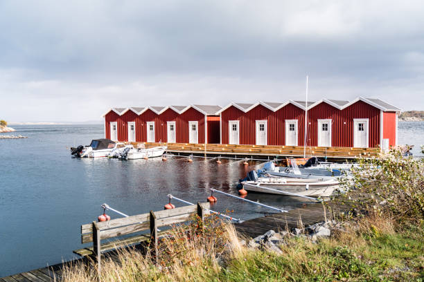 красные дома в гавани острова келлё-книппла, северный архипелаг у гетеборга, швеция - fishing village idyllic red cottage стоковые фото и изображения