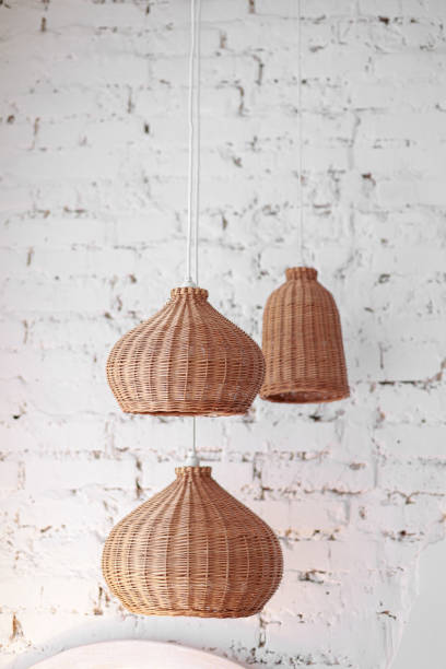 istock three rattan chandeliers different forms on white brick wall background. Straw lampshade in cozy living room. Eco-friendly interior design using natural materials. Scandinavian interior. copy space 1440998018