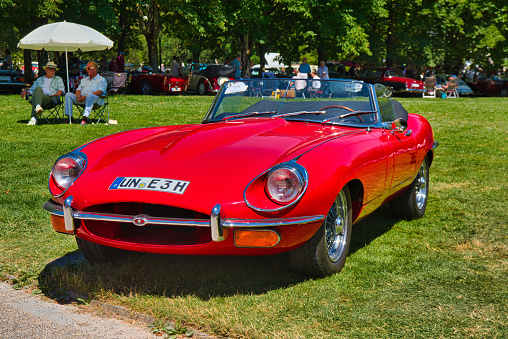 Baden-Baden, Germany - 10 July 2022: red 1961 Jaguar E-Type 3.8 Flat Floor Roadster cabrio is parked in Kurpark in Baden-Baden at the exhibition of old cars \