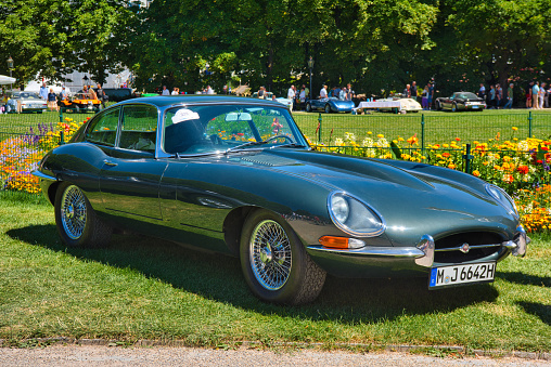 Baden-Baden, Germany - 10 July 2022: green Jaguar E Type S1 3.8 coupe 1963 cabrio roadster is parked in Kurpark in Baden-Baden at the exhibition of old cars \