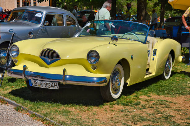 Baden-Baden, Germany - 10 July 2022: light yellow 1954 Kaiser Darrin cabrio roadster is parked in Kurpark in Baden-Baden at the exhibition of old cars \