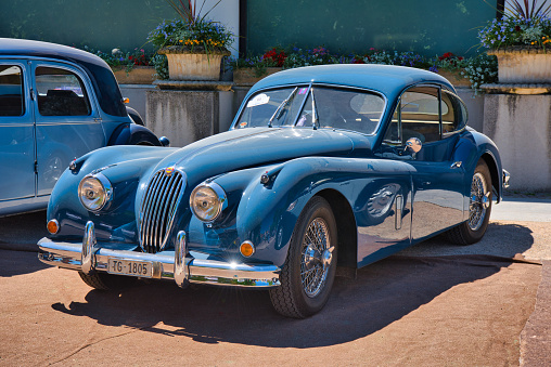 Baden-Baden, Germany - 10 July 2022: blue 1955 Jaguar XK140 Fixed Head Coupe is parked in Kurpark in Baden-Baden at the exhibition of old cars 