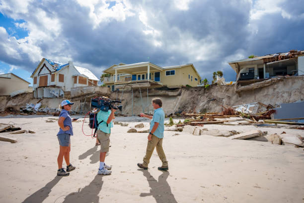 News team reporting live on Daytona Beach after Hurricane Nicole stock photo