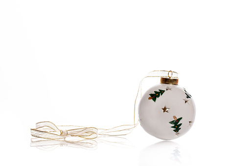 White ceramic christmas ball with a ribbon decoration, isolated on white background