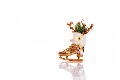 ice skate shaped christmas ornament and reflection on white background