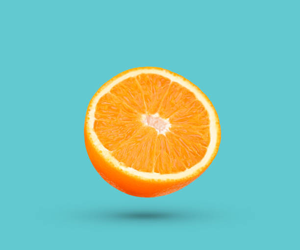 istock Slice of orange fruit falling in the air isolated on blue 1441004572