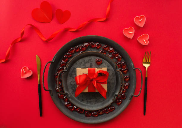 istock Banner. Romantic dinner. Vintage plates, festive table setting with a gift box on a red background. The concept of love. Valentine's Day. 1441004678