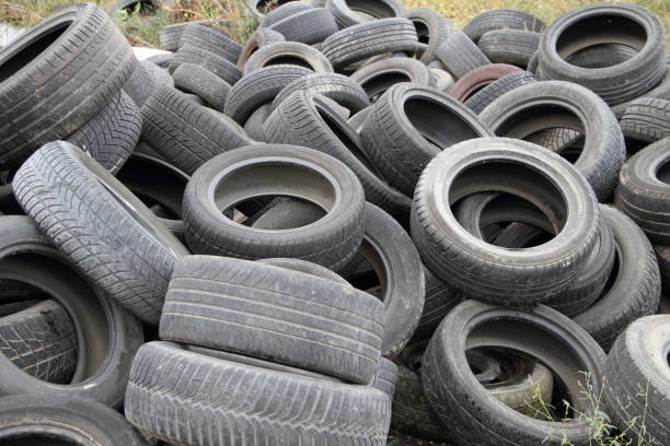 old tires discarded in nature stock photo