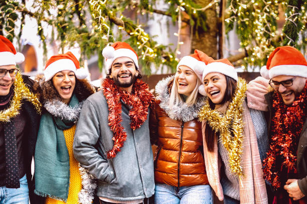 istock Young people group walking around Christmas tree decorations - Winter life style concept with trendy happy friends wearing red santa claus hats having fun holiday together outside - Warm bright filter 1441006897
