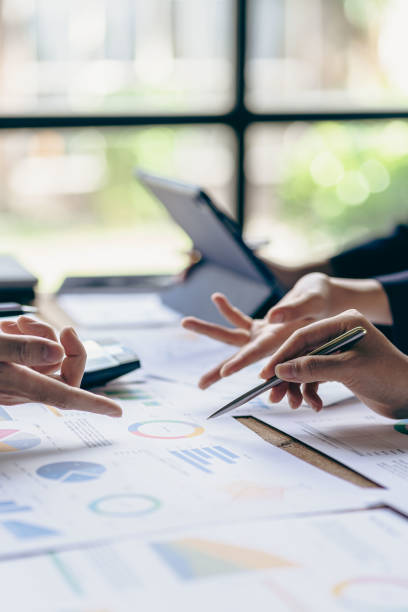 istock Young colleagues working together on startup projects in modern office Businessman brainstorming analyzing financial graphs calculating company earnings Vertical photo, flare 1441008606