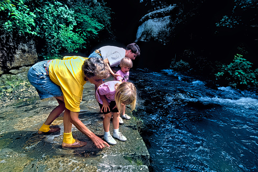 Roaring River State Park, Missouri USA June 13, 1998: Two mothers and their children explore the headwaters of Roaring River where water flows from a chasm between two bluffs at Roaring River State Park in the Missouri Ozarks