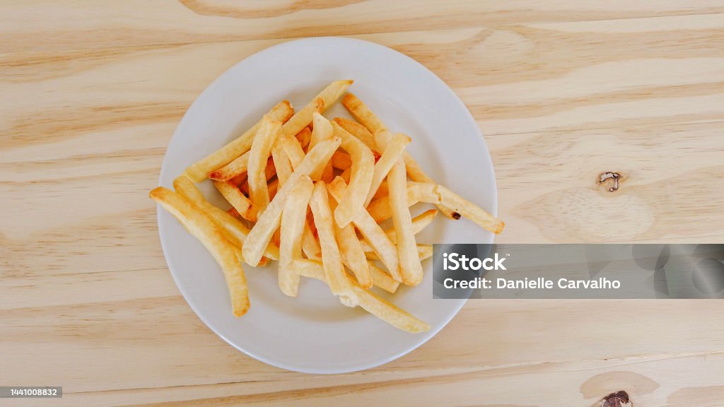 French fries on a plate top view. Wooden table Backgrounds Stock Photo