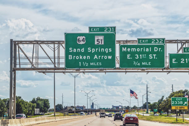 08-07-2022 Tulsa OK USA Driving into Tulsa OK from the East on Highway 44 with traffic, signs to Sand Springs and Broken Arrow and American flag 08-07-2022 Tulsa OK USA Driving into Tulsa OK from the East on Highway 44 with traffic, signs to Sand Springs and Broken Arrow and American flag garfield county montana stock pictures, royalty-free photos & images