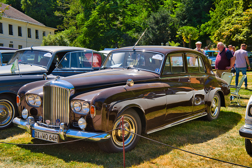 Baden-Baden, Germany - 10 July 2022: red maroon Rolls-Royce Silver Cloud 1959 is parked in Kurpark in Baden-Baden at the exhibition of old cars \