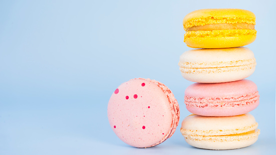 Multicolored macaroon cakes on a blue background