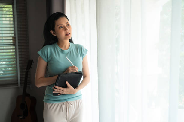 istock Entrepreneur Asian woman using digital tablet while planning her business at home 1441014381