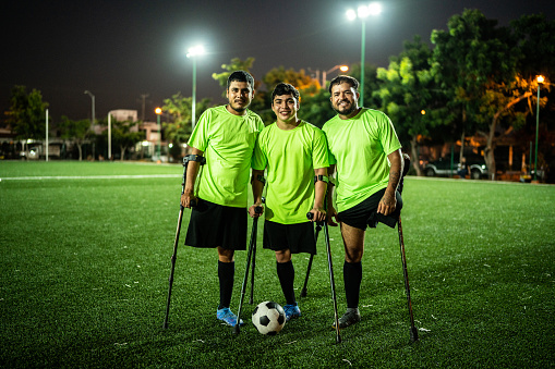 Portrait of amputee soccer players with soccer ball on soccer field