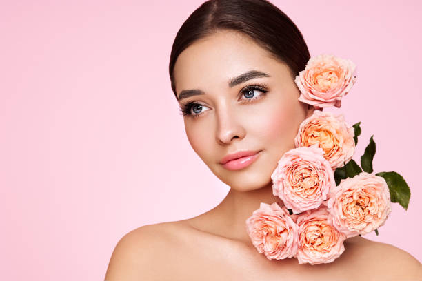 istock Beautiful young woman with a rose flower 1441014607