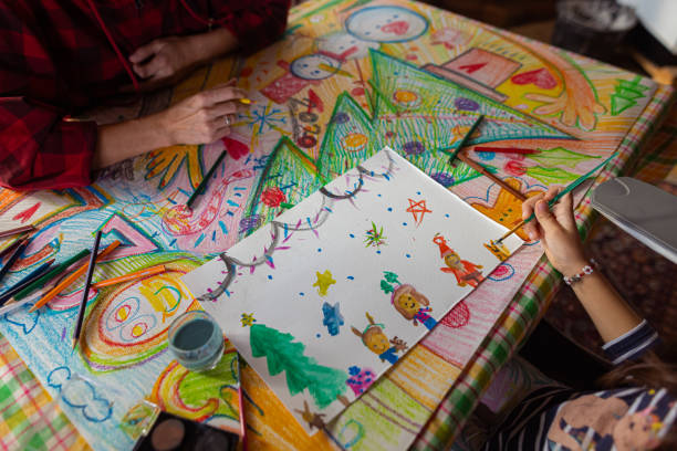 istock Creative girl making a Christmas art while her mother helping her 1441015360