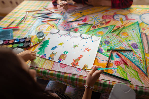 istock Creative girl making a Christmas art while her mother helping her 1441015361