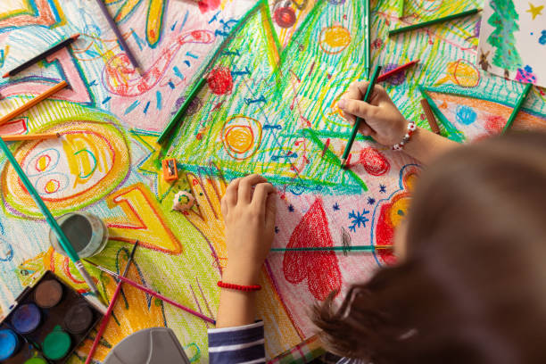 istock Creative girl using a colored pencil to draw a Christmas theme on the paper 1441016568