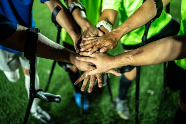 istock Close-up of amputee soccer players stacking hands 1441017503