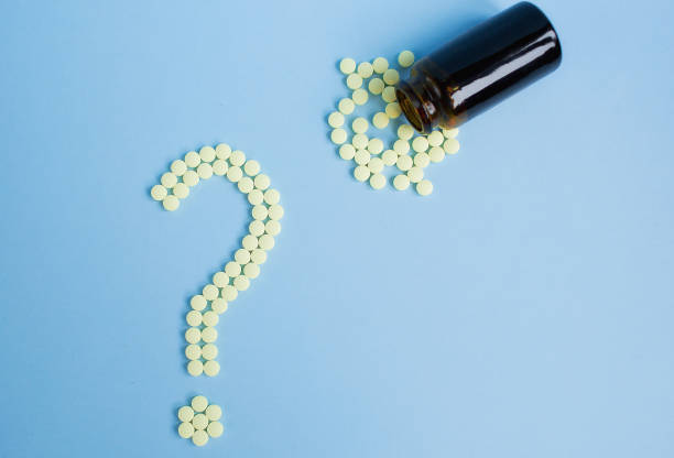 istock Assorted pharmaceutical medicine pills, tablets and capsules and bottle on blue background. Drugs and various narcotic substances. Copy space for text. Stock photo for design. 1441024510