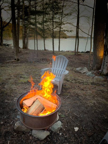istock Chair by campfire against trees and lake 1441025094