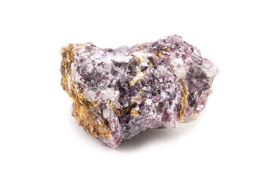 A fragment of the mineral lepidolite with a rough crystalline surface of a pinkish color. Isolated on white background.