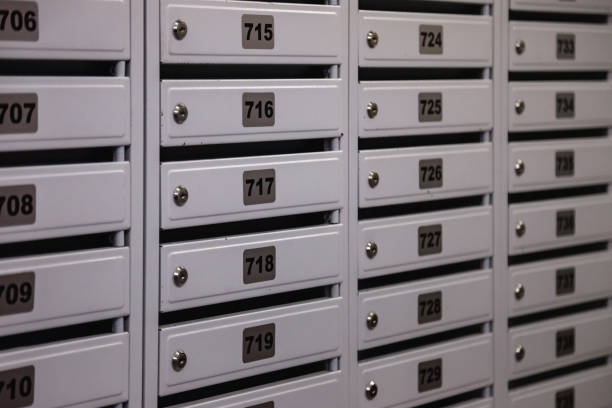 istock Backdrop of white Mailboxes in an apartment residential building, full frame. Background of rows of numbered mailbox in residential apartment building. Correspondence concept. Copy text space 1441027188