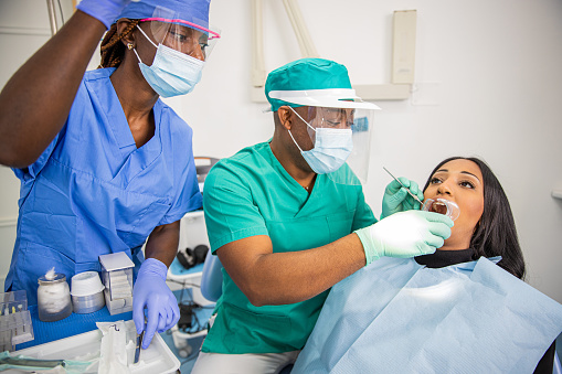 A dentist checks a patient's teeth in an African dental clinic
