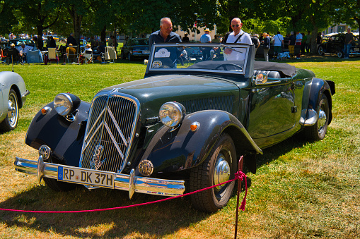 Baden-Baden, Germany - 10 July 2022: black Citroen Traction Avant 1954 cabrio roadster is parked in Kurpark in Baden-Baden at the exhibition of old cars \