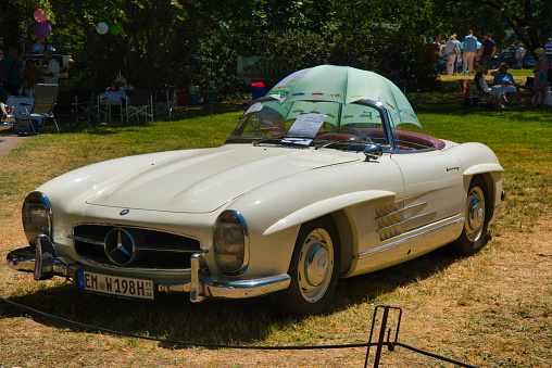 Baden-Baden, Germany - 10 July 2022: white Mercedes-Benz 300 SL W198 1957 cabrio roadster is parked in Kurpark in Baden-Baden at the exhibition of old cars 