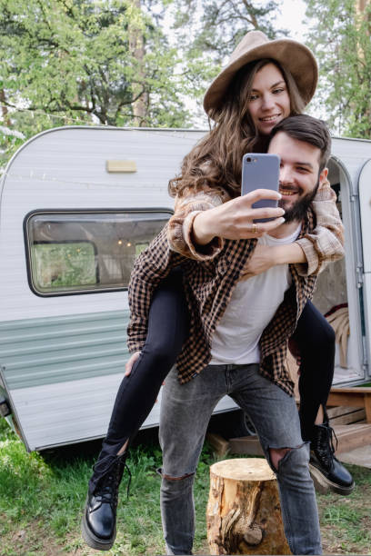 istock Man giving piggyback ride to girlfriend, having fun and taking a selfie 1441031774