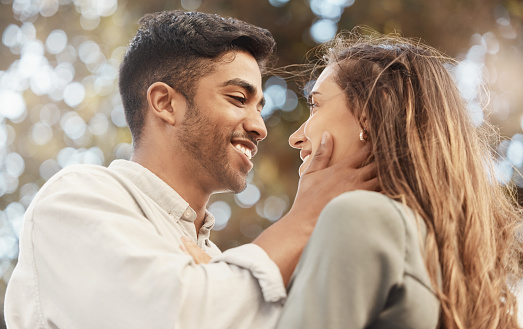Happy couple, love and commitment while outside at a park sharing a romantic moment and looking into eyes with a smile. Safe, secure and happy man and woman showing appreciation, bond and connection
