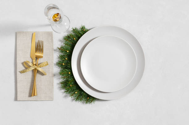 istock Christmas table setting with empty plate, golden cutlery and a glass on a gray background. Happy new year. Space for text. Winter concept. Top view, flat lay. 1441035178