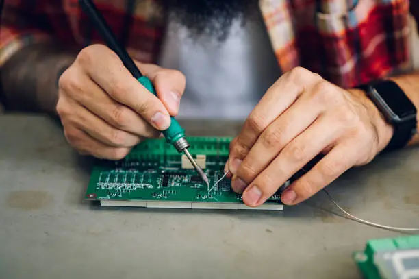 Photo of Electronics engineer working in a workshop with tin soldering parts