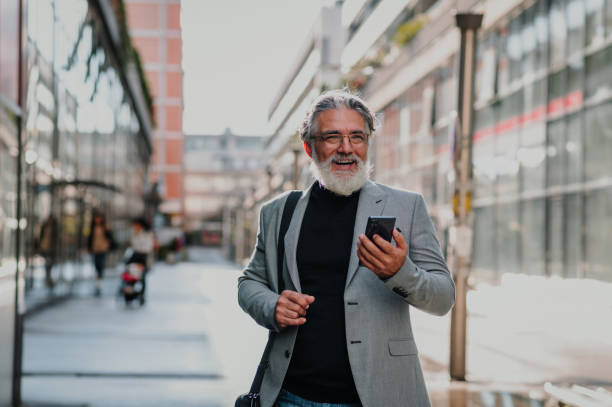 istock Senior businessman standing outside and using smartphone 1441035365