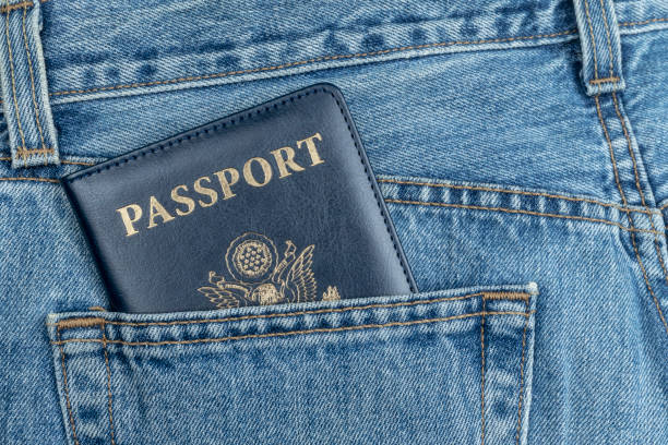 CLOSE UP OF USA PASSPORT IN BLUE JEANS POCKET. TOURIST AND TRAVELER CONCEPT FROM UNITED STATES OF AMERICA. CLOSE UP OF USA PASSPORT IN BLUE JEANS POCKET. TOURIST AND TRAVELER CONCEPT FROM UNITED STATES OF AMERICA. voyager 1 stock pictures, royalty-free photos & images