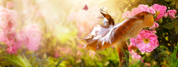 Girl in dress and hat sitting on mushroom and releasing butterfly from hand in fantasy magical enchanted fairy tale rose flower blooming garden, fairytale floral fabulous background Elf woman in dress and hat sitting on fantasy giant large mushroom and releasing butterfly from hand in magical enchanted fairy tale rose flower blooming garden, fairytale floral fabulous background fairy rose stock pictures, royalty-free photos & images