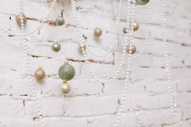 Christmas, New Year composition. Antler with shiny white, gold, green balls and pearl necklaces on white brick wall. Scandinavian cozy home decor. Happy Holidays, Template. Greeting card. 2023. composición de navidad, año nuevo. asta con bolas blancas brillantes, doradas, verdes y collares de perlas en pared de ladrillo blanco. decoración escandinava acogedora para el hogar. felices fiestas, plantilla. tarjeta de felicitación. 2023