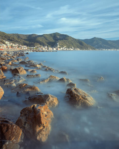 The rocky seashore by the small town on the Italian Riviera on a summer day stock photo