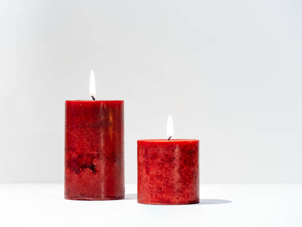 istock Ornate red candles burning against a light background 1441044336