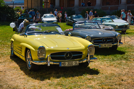 Baden-Baden, Germany - 10 July 2022: lemon yellow Mercedes-Benz 300 SL W198 1957 cabrio roadster is parked in Kurpark in Baden-Baden at the exhibition of old cars 