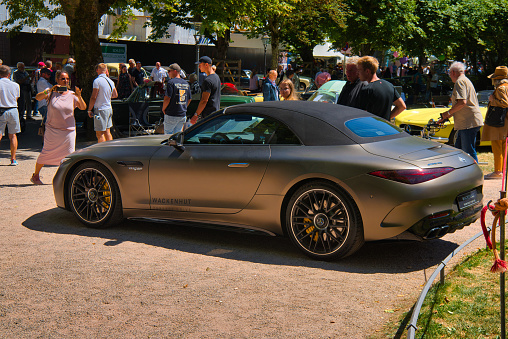 Baden-Baden, Germany - 10 July 2022: gray sand Mercedes-AMG SL 63 R232 2022 is parked in Kurpark in Baden-Baden at the exhibition of old cars \