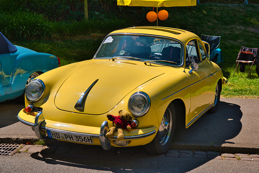 Baden-Baden, Germany - 10 July 2022: yellow Porsche 356 1948 coupe is parked in Kurpark in Baden-Baden at the exhibition of old cars 