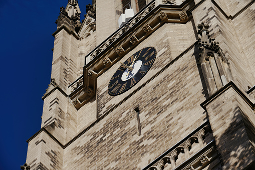 tower clock of a historic church in cologne in front of a deep blue sky