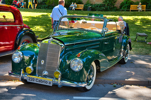 Baden-Baden, Germany - 10 July 2022: green Mercedes-Benz W187 1951 cabrio roadster is parked in Kurpark in Baden-Baden at the exhibition of old cars \