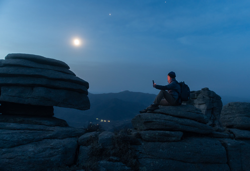 Hikers reading in the moonlight on the mountain